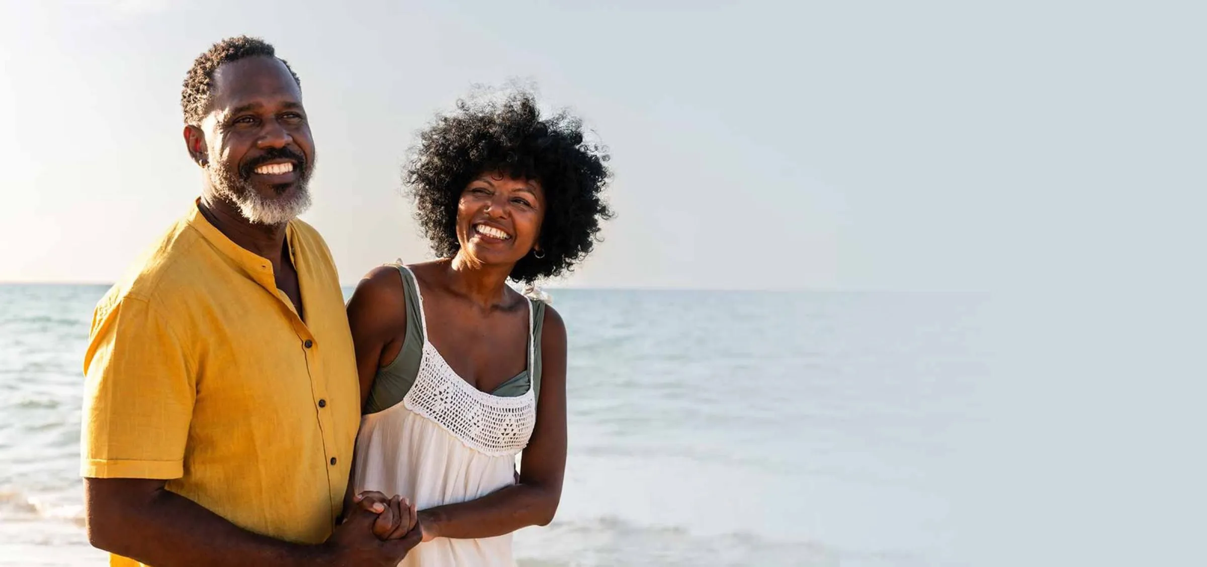 An older couple smiling together by the water