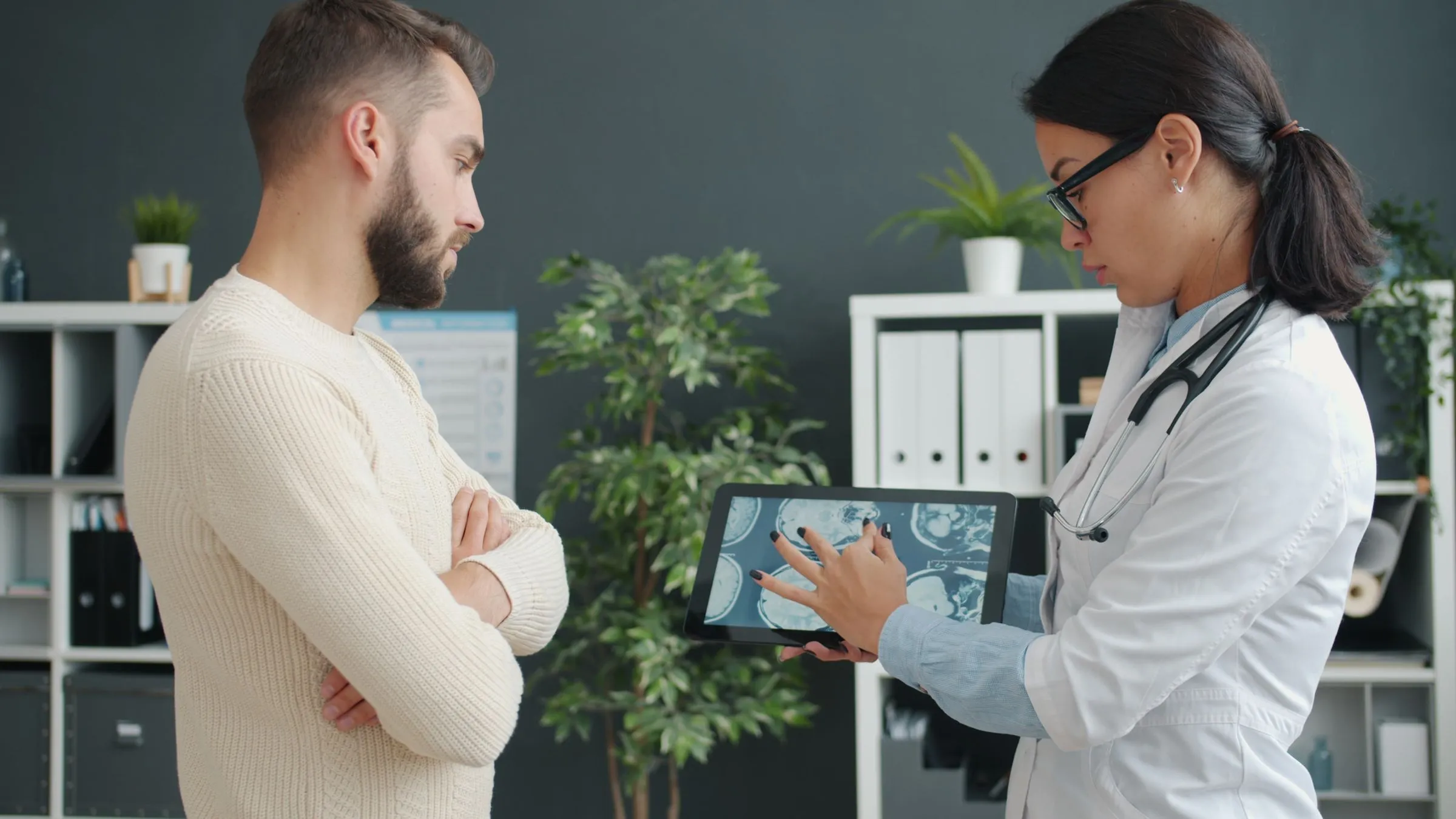 A clinician explaining information on a screen to an older patient
