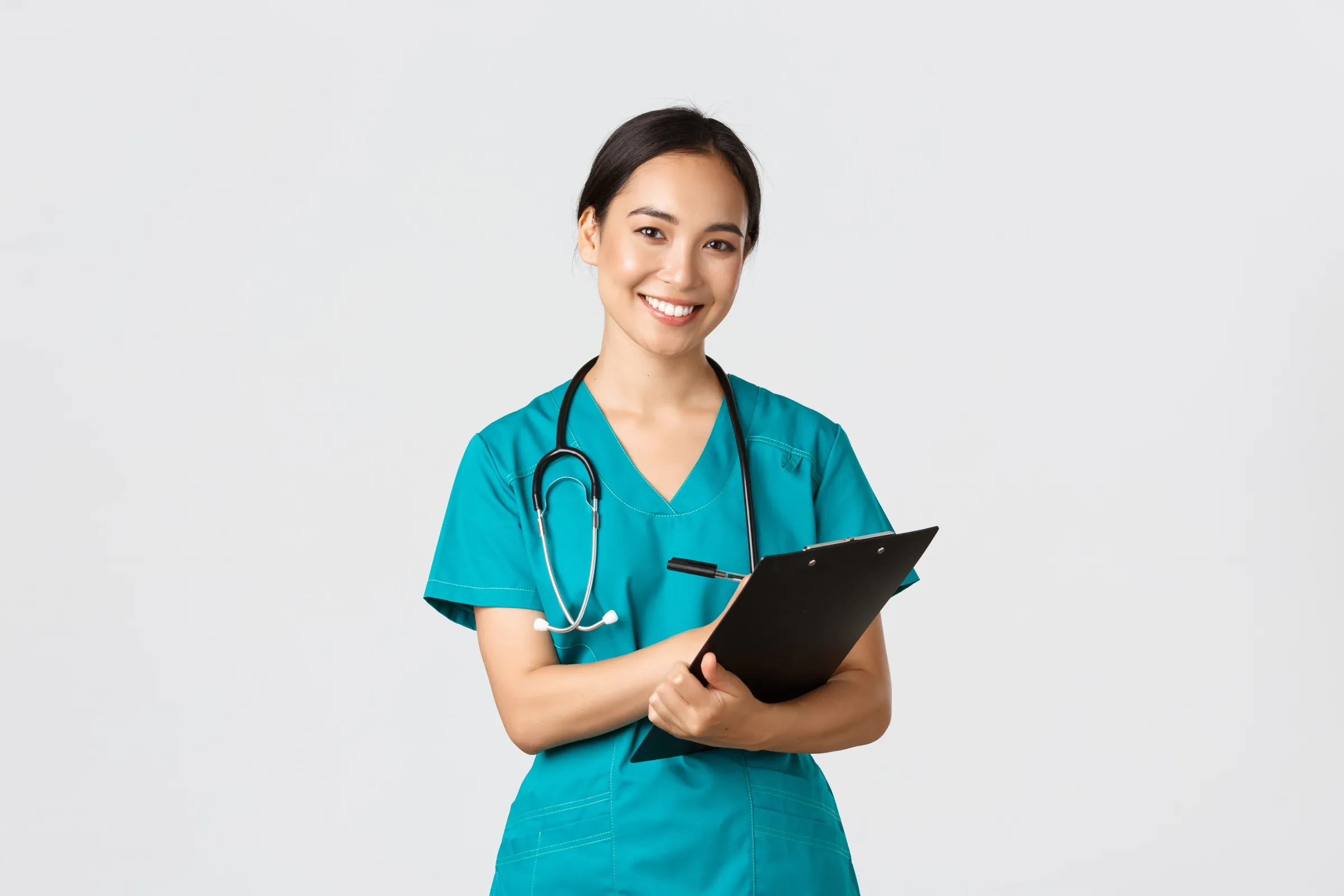 A nurse practitioner holding a clipboard and smiling