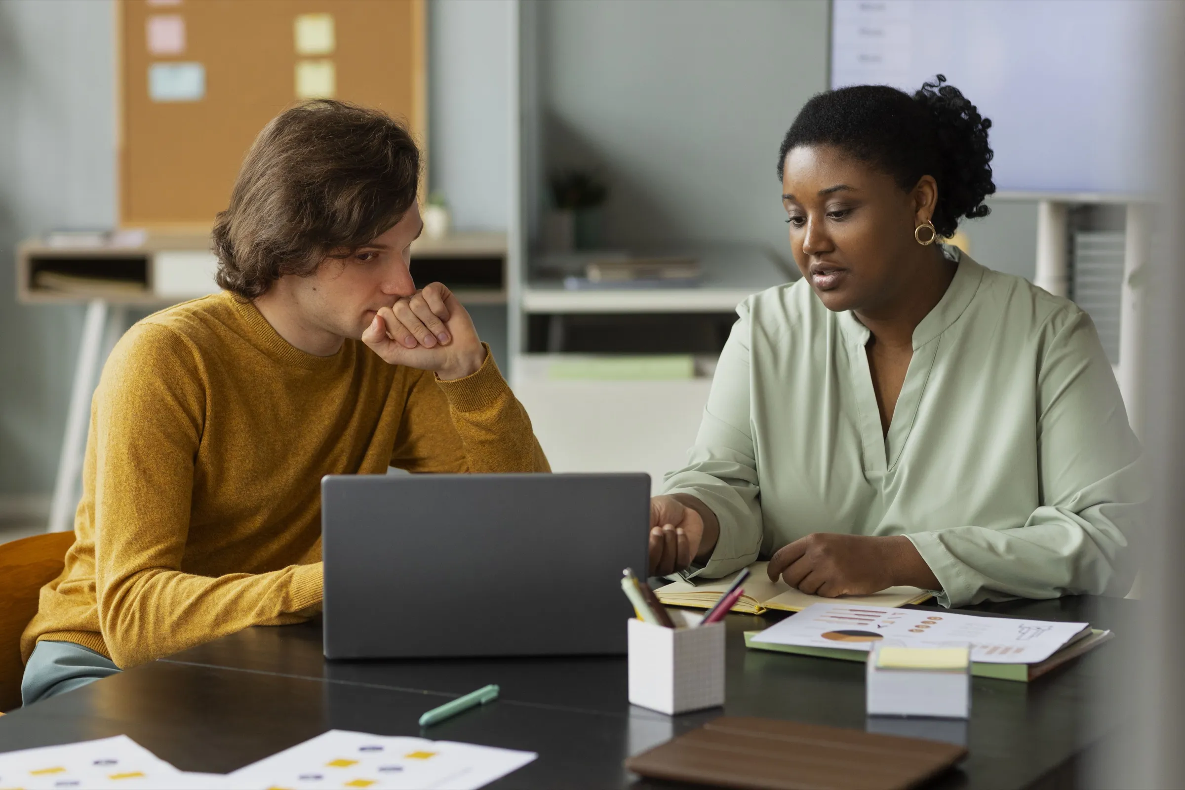 Colleagues reviewing research together at a desk