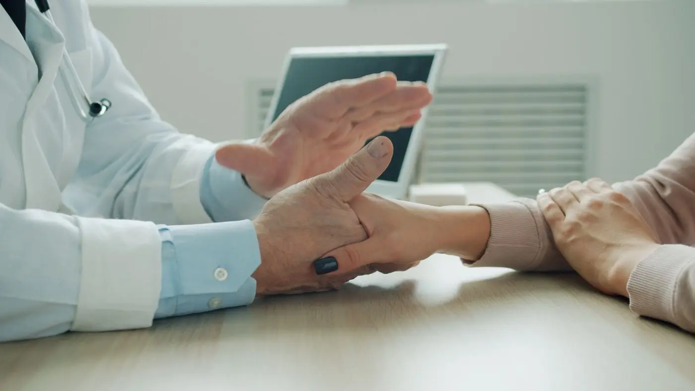 A doctor examining a patient’s wrist during a consultation